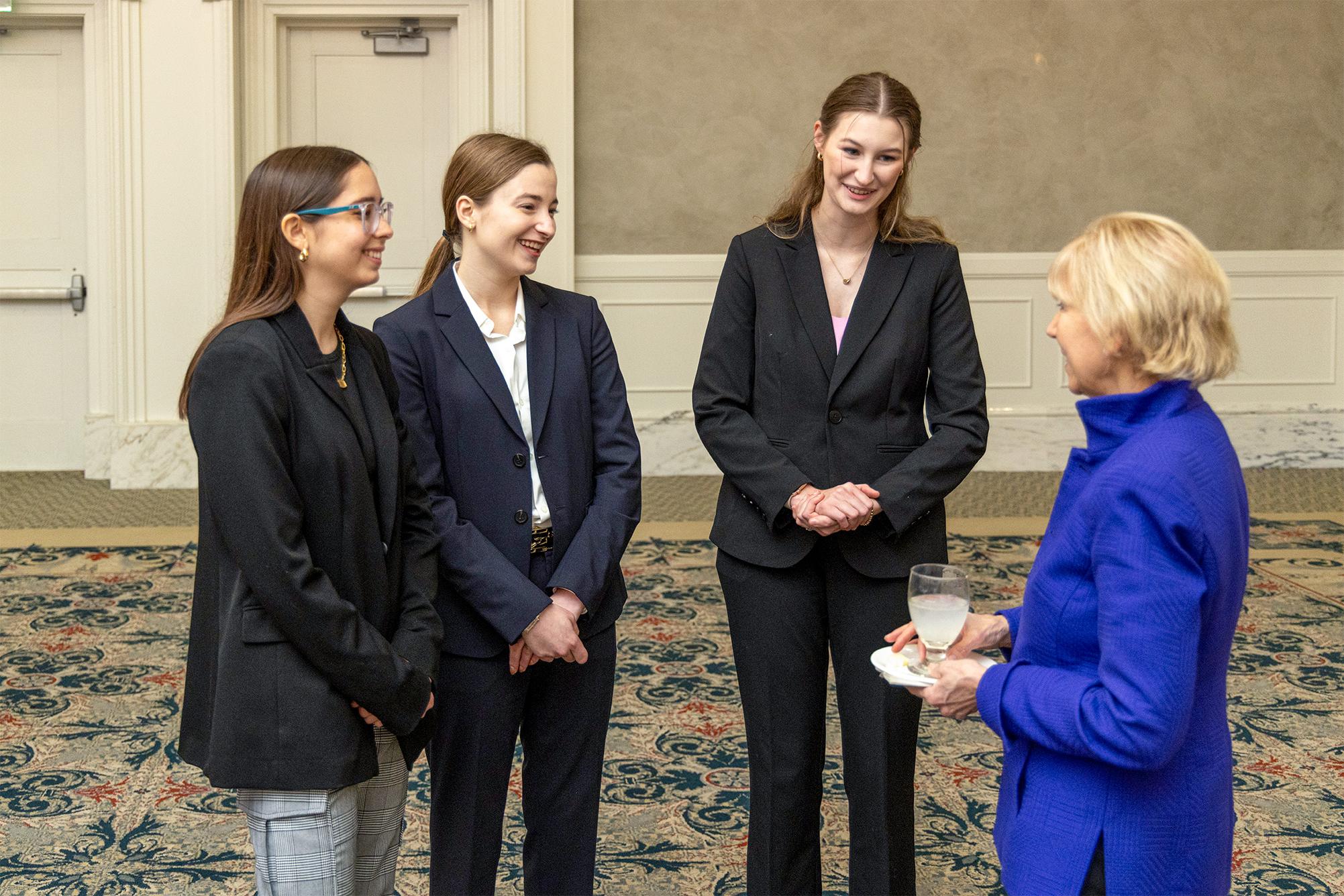 Three students talking to a Board member